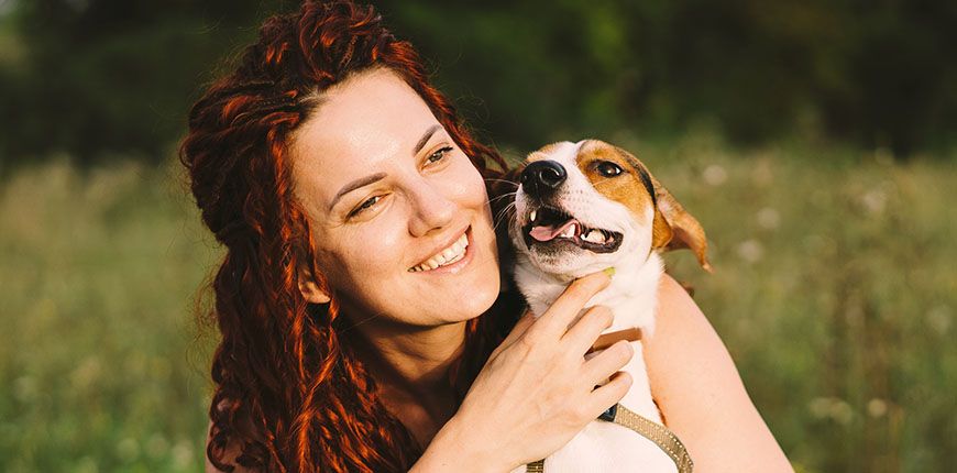 beautiful woman plays with her jack russell dog at park